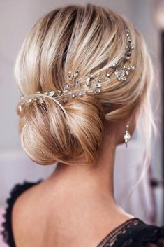 a woman wearing a hair comb with pearls on it's head and her hair in a low bun