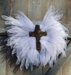 a white tutu with a cross on it sitting on top of a piece of wood