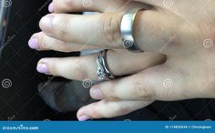 a woman's hand with two wedding rings on her fingers