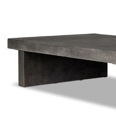 a concrete coffee table sitting on top of a white floor