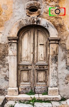 an old stone building with two doors and a stop light in front of the door