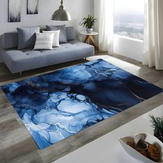 a living room with a couch and rugs on the floor in front of a window