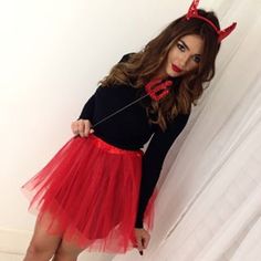 a girl in a red tutu and black shirt is posing for the camera with her hands on her hips