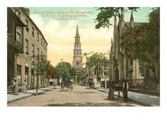 an old postcard shows people walking down the street in front of buildings and a church steeple