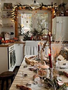 a table is set with candles and other items for the holiday dinner in the kitchen