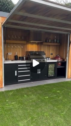 a large outdoor kitchen with an oven and sink in the middle of some green grass