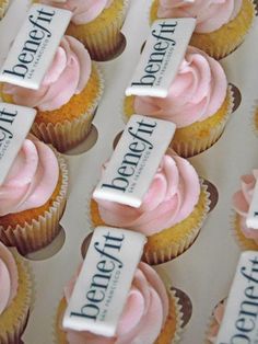 cupcakes with pink frosting and white labels on them