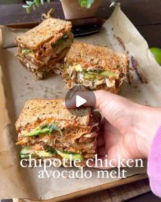 someone is holding a sandwich in their hand and pointing to it with the word chipotie chicken avocado melt