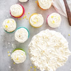 cupcakes with white frosting and yellow sprinkles on a table