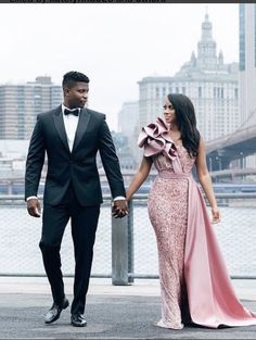 a man in a tuxedo walking next to a woman in a pink dress