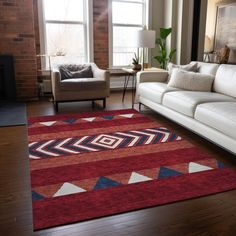 a living room with white couches and a red rug in front of a window