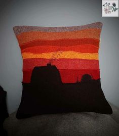 an orange and red striped pillow sitting on top of a couch