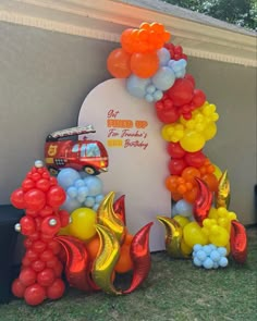 the balloon arch is decorated with balloons and firetrucks