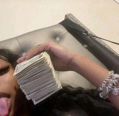 a woman sticking her tongue out and holding stacks of papers in front of her face