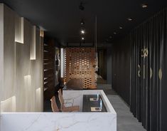 an office with marble counter tops and wooden partitions on the wall, along with chairs