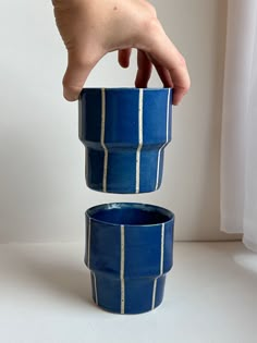 a hand is reaching into two blue bowls