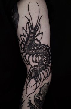 a man's arm with tattoos on it and a scorpion tattoo on the arm