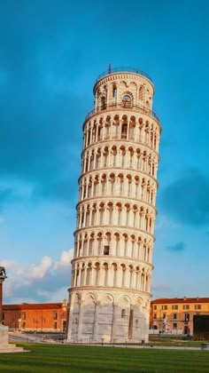 the leaning tower of pisa in italy against a blue sky with clouds and green grass