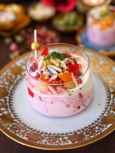 a dessert with fruit, nuts and other toppings in a glass dish on a plate