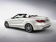 a white convertible car parked in an empty room