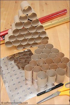 several rolls of toilet paper are arranged on a table with scissors, tape and pencils