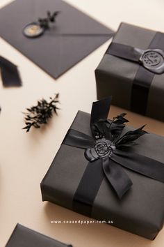 black gift boxes with ribbons and buttons on them