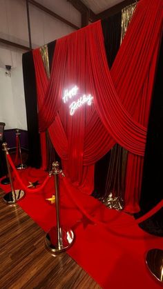 a red carpeted room with black and white walls, gold accents and metal poles