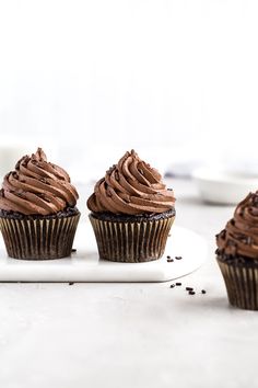 three chocolate cupcakes on a white plate