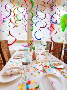 the table is set for a party with confetti and streamers