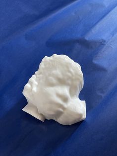 a white piece of plastic sitting on top of a blue sheet