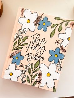 an open bible with flowers on it