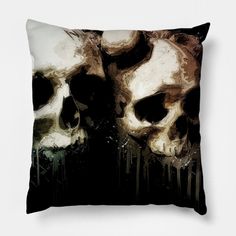 two skulls are shown on a black pillow with white paint splattered over them