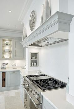 a white kitchen with an oven, stove and counter tops in the middle of it