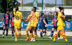 the women's soccer team is playing against each other on the field in yellow uniforms