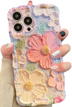 a woman holding up her phone case with flowers on it