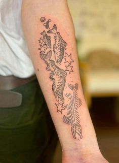 a person with a tattoo on their arm that has fish and stars all over it