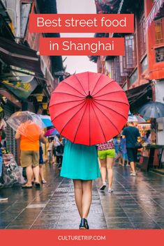 a woman walking down the street with an umbrella over her head and text that reads best street food in shanghai