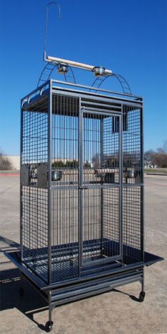 a metal birdcage sitting on top of a parking lot next to a free sign