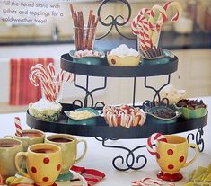 there is a three tiered tray with candy canes and cupcakes on it