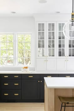 a kitchen with black cabinets and white counter tops