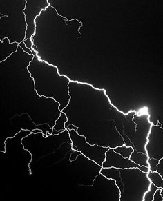 lightning strikes across the night sky in black and white