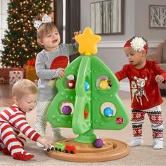 three children playing with a christmas tree toy