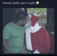 a man in a santa suit kissing another man's face with the caption, homie really want a ps5