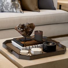 a living room with a couch, coffee table and candles on it's tray