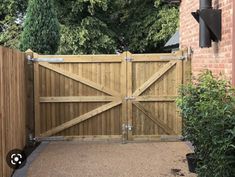 a wooden gate in front of a brick building