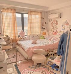 a room with a bed, desk and chair in it that has hello kitty decorations on the walls