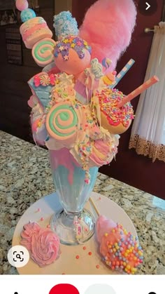 a vase filled with cupcakes and marshmallows on top of a counter