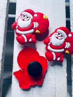 three red santa clause cookies sitting on top of a white table