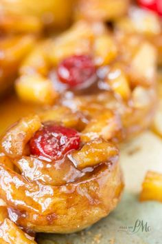 some kind of pastry that is on a plate with pineapples and cherries