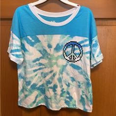 Justice Girls Size 12/14 Color Block Cuff Tee In A Blue Tie Dye. This Cute Tee Has A Glittery Graphic With Dye Effect- Perfect For All Her Everyday Adventures. 60% Cotton, 20% Polyester And 20% Recycled Polyester. New With Tags, Smoke Free Home. Cute Blue Tops With Graphic Print, Playful Tie Dye Tops For Summer, Blue Crew Neck Top With Fun Style, Blue Crew Neck Fun Tops, Cute Tie Dye Crew Neck Top, Fun Blue Spring Tops, Fun Blue Crew Neck Top, Blue Fun Spring Tops, Light Blue Crew Neck Top